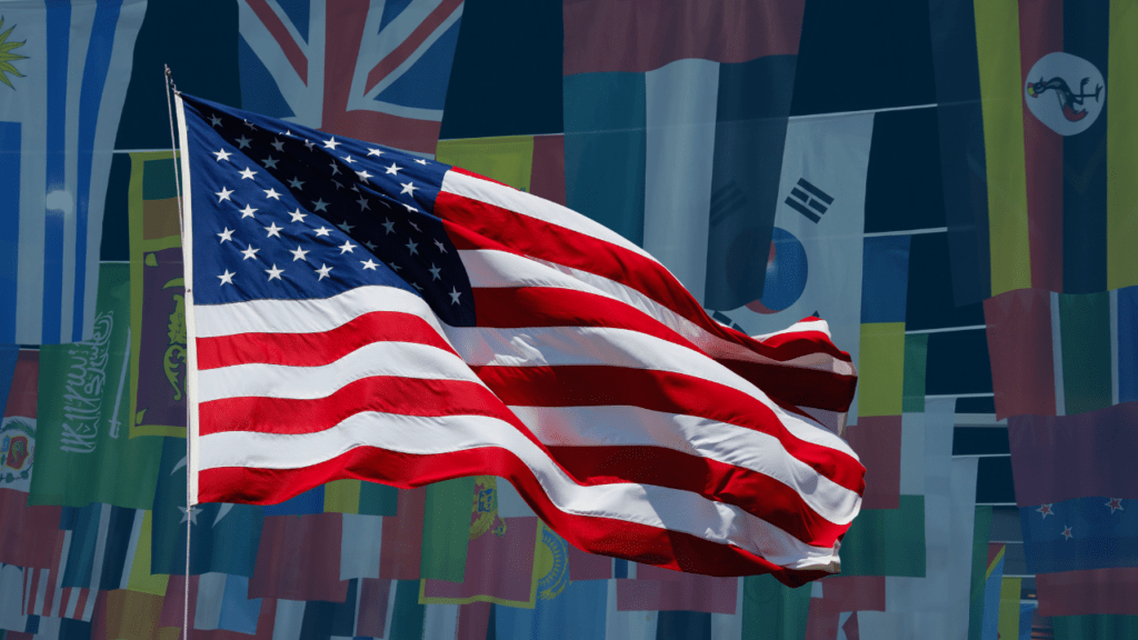 Image of a US flag with a background of other country flags that are faded in the background